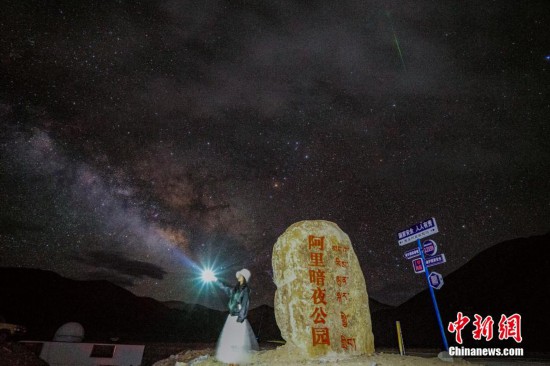 圖為6月20日晚，游客“打卡”西藏阿里暗夜公園，天上是銀河與流星（右上角）。曹枝清 攝